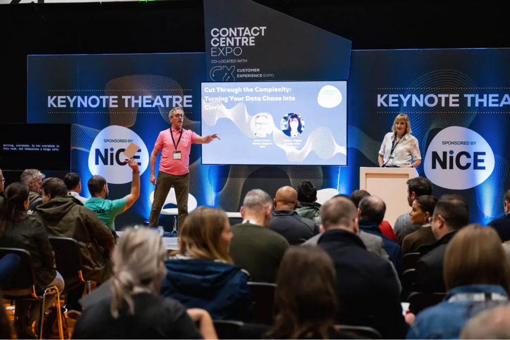 Speaker on stage at Contact Centre Expo Keynote Theatre presenting to seated audience.