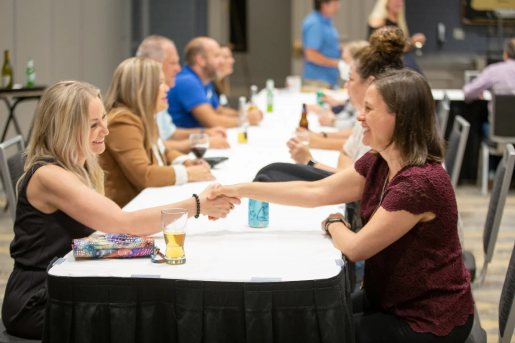 Attendees interacting during a one-on-one meeting at the Customer Contact West