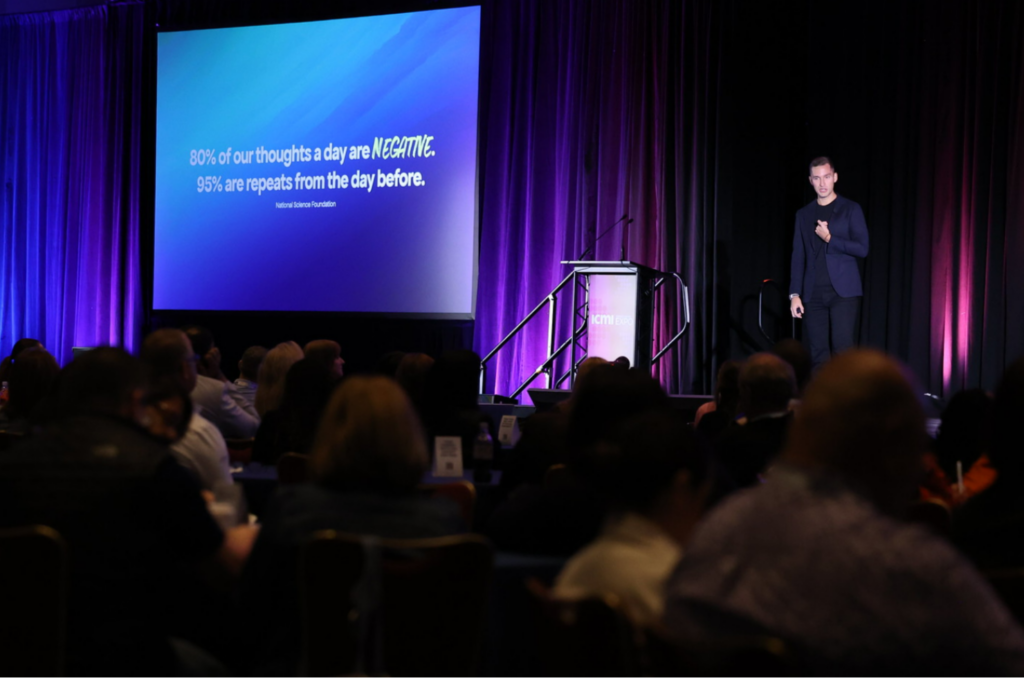 A presenter on stage at the ICMI Contact Center Expo