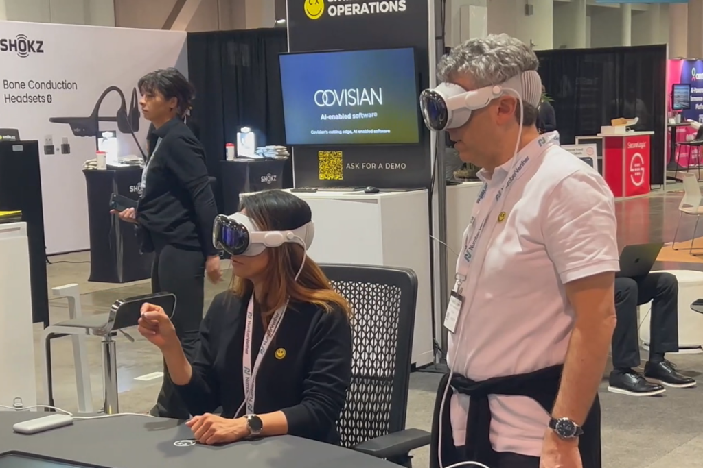 Two attendees participate in a technology demonstration at an exhibitor booth during Customer Connect Expo.